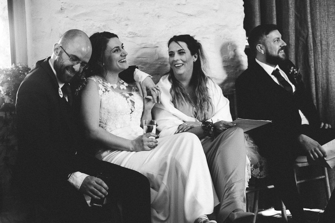 005 CANDID MOMENT BRIDAL PARTY DURING SPEECHES JON AND LAURAS BARN AT BRYNICH BRECON WEDDING PHOTOGRAPHY
